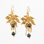 ARETES FLOR VAINILLA TURMALINA NEGRA: Pureza en Contraste