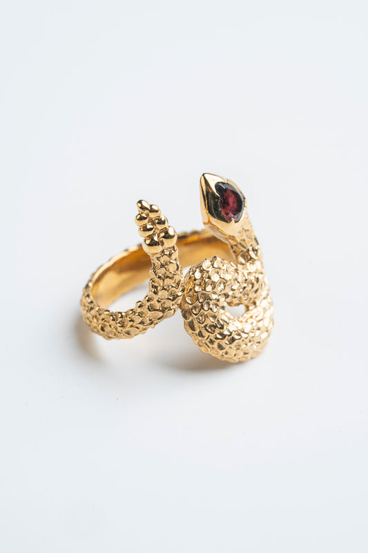 Anillo Serpiente Granate: La elegancia dorada de la renovación.